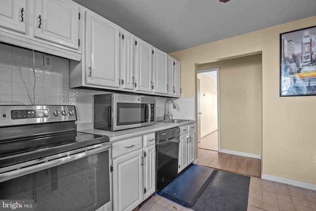 kitchen with light tile patterned floors, appliances with stainless steel finishes, decorative backsplash, white cabinets, and sink