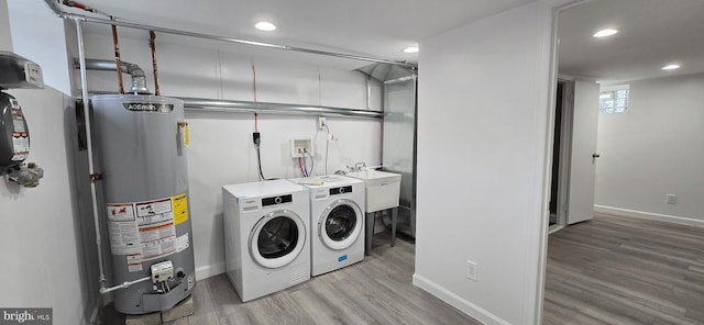 laundry room featuring separate washer and dryer, light wood-type flooring, and gas water heater