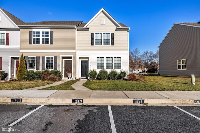 townhome / multi-family property featuring a front lawn