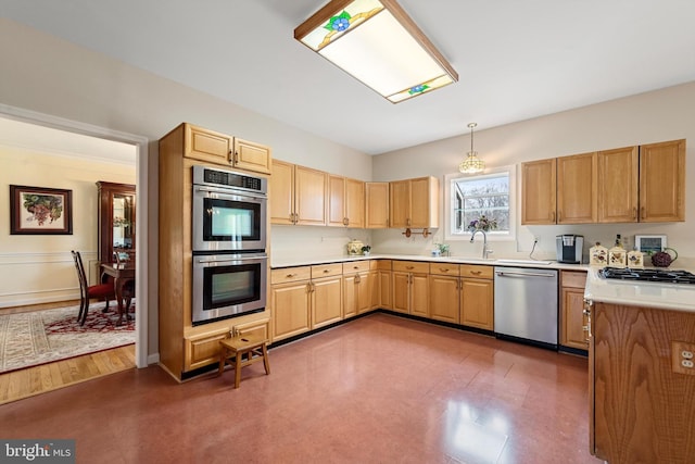 kitchen with light brown cabinetry, appliances with stainless steel finishes, and pendant lighting