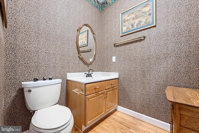 bathroom featuring toilet, hardwood / wood-style flooring, and vanity