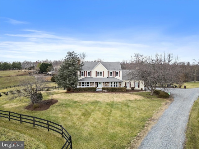 view of front facade featuring a front lawn, a rural view, and covered porch