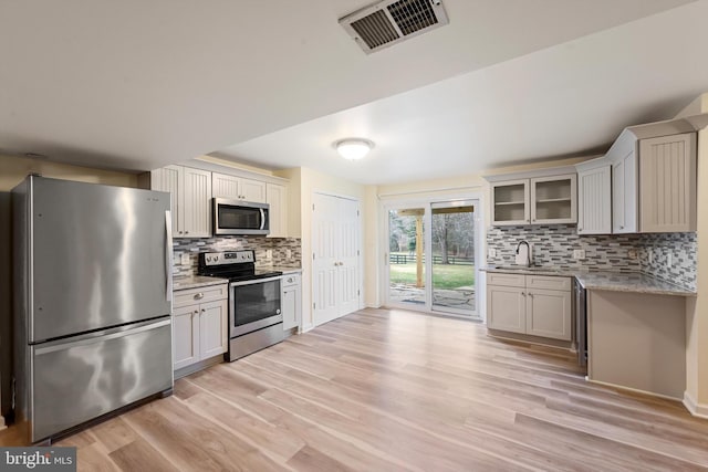 kitchen featuring white cabinets, light wood-type flooring, sink, and stainless steel appliances