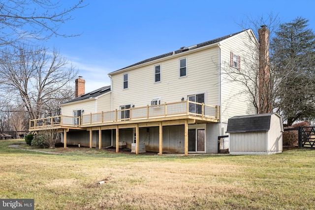 rear view of house with a wooden deck, a shed, and a lawn