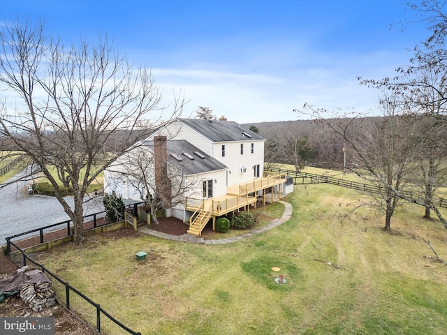 back of property with a lawn and a wooden deck