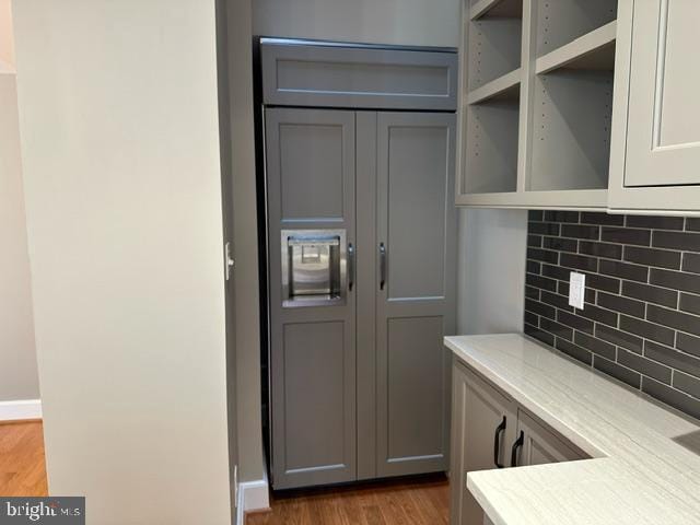 kitchen with hardwood / wood-style flooring, gray cabinets, and tasteful backsplash