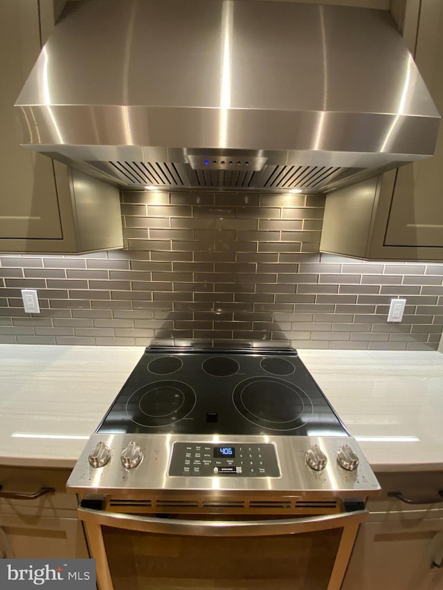 1750 S St NW Unit 1, Washington, DC 20009 - kitchen view of wall chimney exhaust hood, stainless steel electric stove, backsplash, and light countertops