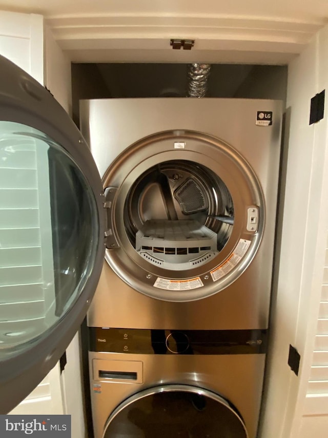 washroom with stacked washing maching and dryer