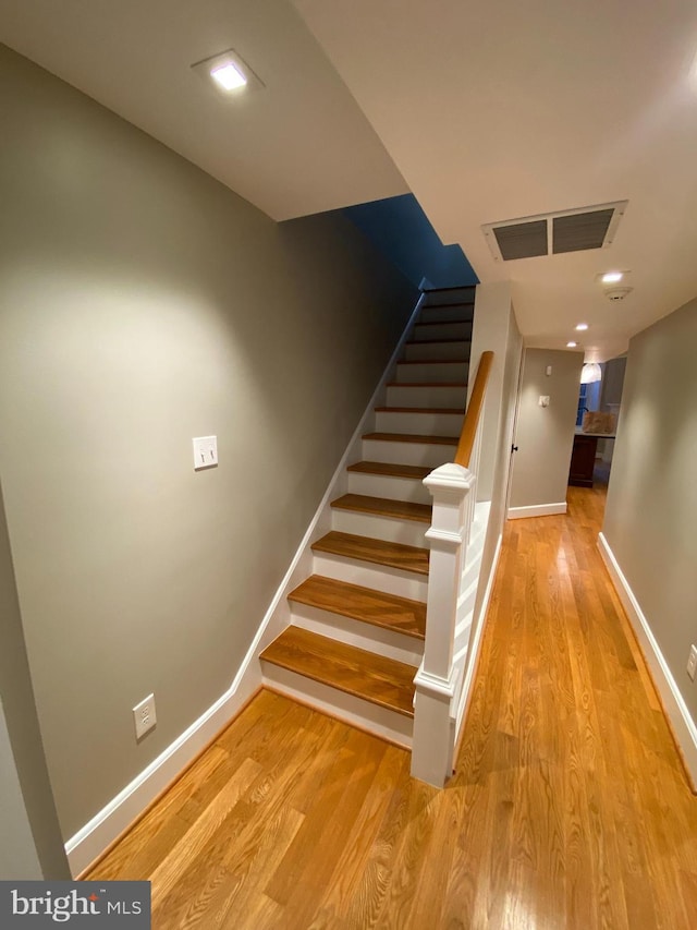 stairs featuring hardwood / wood-style flooring