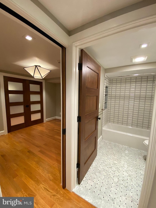 bathroom with hardwood / wood-style floors and a bath