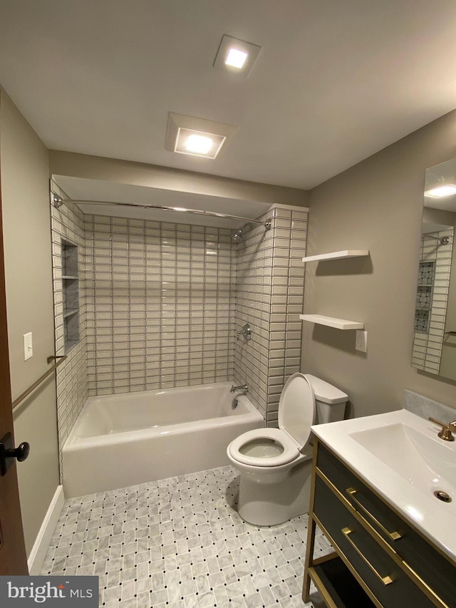 full bathroom featuring vanity, tiled shower / bath, and toilet