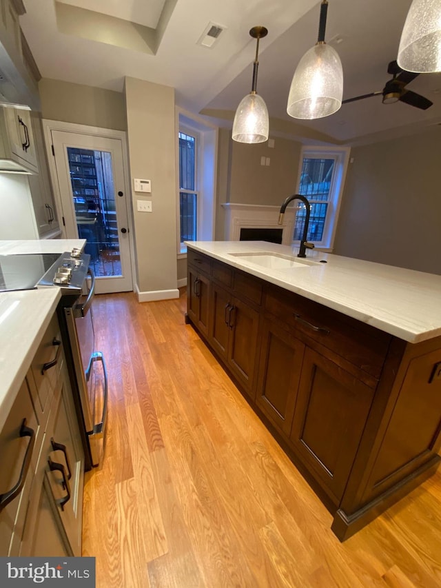 1750 S St NW Unit 1, Washington, DC 20009 - kitchen with stainless steel range with electric cooktop, light countertops, light wood finished floors, and a fireplace