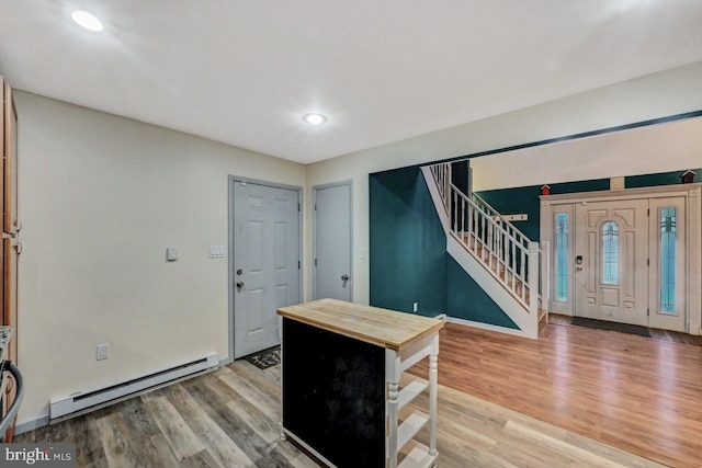 foyer featuring hardwood / wood-style floors and a baseboard heating unit