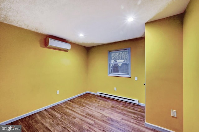 unfurnished room featuring baseboard heating, wood-type flooring, and a wall mounted air conditioner