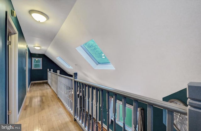 corridor featuring lofted ceiling and hardwood / wood-style flooring