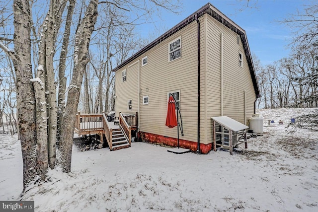 snow covered rear of property featuring a wooden deck