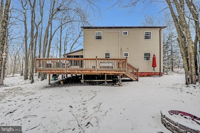 snow covered property featuring a wooden deck