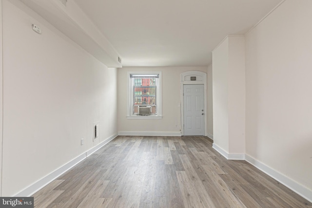 unfurnished room with cooling unit and light hardwood / wood-style flooring