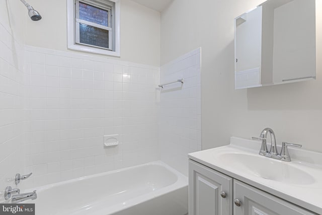 bathroom featuring vanity and tiled shower / bath