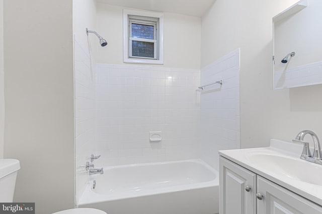 full bathroom with vanity, tiled shower / bath combo, and toilet