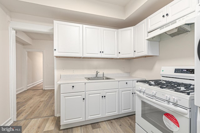 kitchen with sink, white cabinets, light hardwood / wood-style floors, and white gas range oven