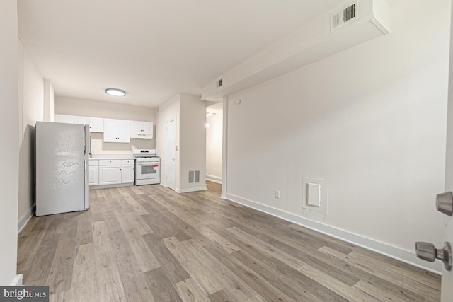 kitchen featuring white appliances, light hardwood / wood-style flooring, and white cabinetry