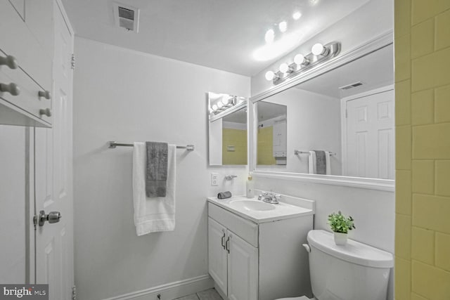 bathroom with tile patterned flooring, vanity, and toilet