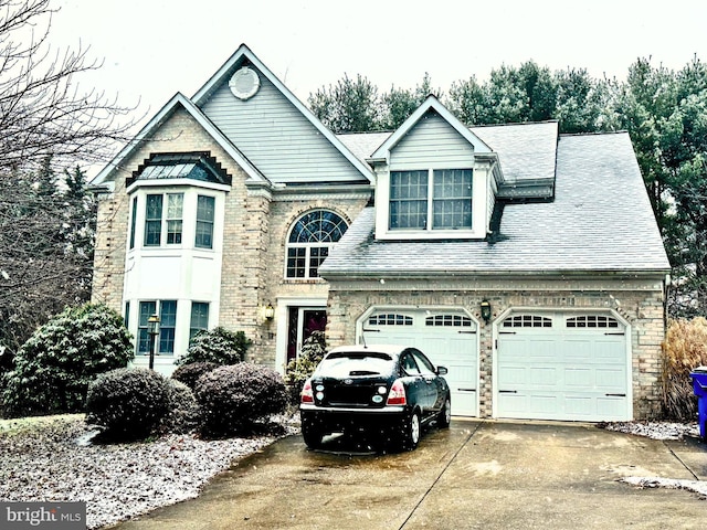 view of front of home featuring a shingled roof and driveway