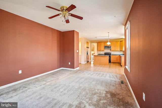 unfurnished living room with ceiling fan and light carpet