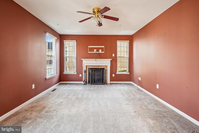 unfurnished living room featuring ceiling fan and carpet