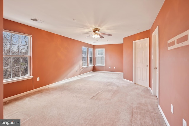 unfurnished bedroom featuring ceiling fan, light carpet, and multiple windows