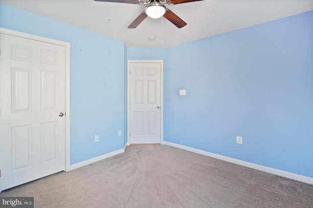 spare room featuring light colored carpet and ceiling fan