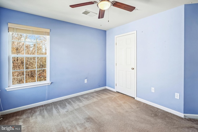 carpeted spare room featuring ceiling fan