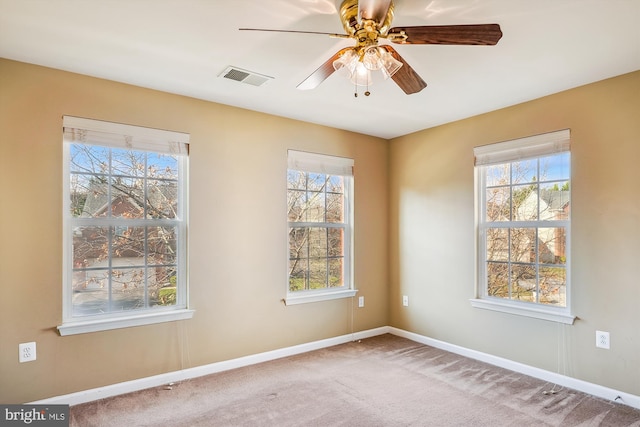 carpeted empty room featuring plenty of natural light and ceiling fan