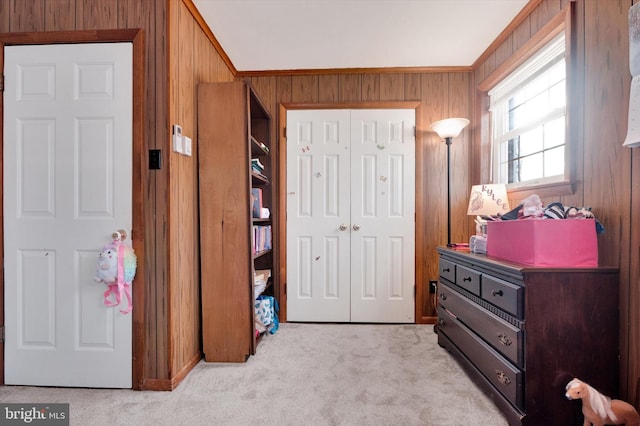 carpeted bedroom with crown molding and wood walls