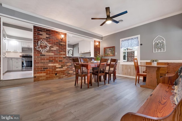 dining space featuring light hardwood / wood-style flooring, ceiling fan, and crown molding