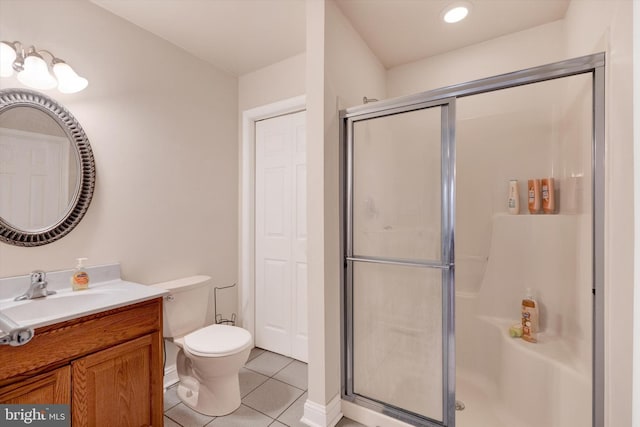 bathroom with tile patterned flooring, vanity, toilet, and a shower with shower door