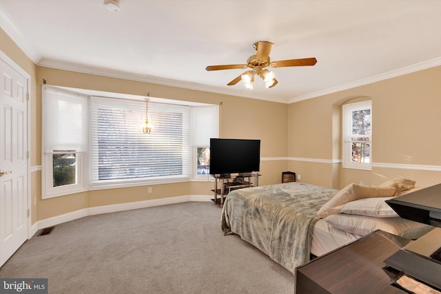 carpeted bedroom featuring ceiling fan and crown molding