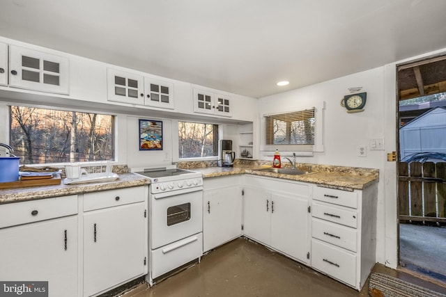 kitchen featuring white cabinets, white range oven, and sink