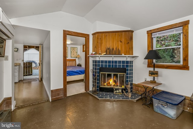 living room with a wall mounted AC, a fireplace, concrete floors, and lofted ceiling