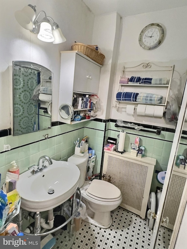 bathroom with sink, tile patterned flooring, decorative backsplash, toilet, and tile walls