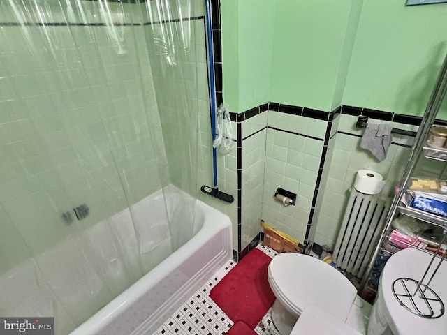 bathroom with tile patterned floors, toilet, shower / bath combo with shower curtain, tile walls, and radiator heating unit