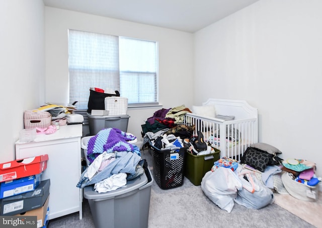 bedroom featuring carpet flooring and a nursery area