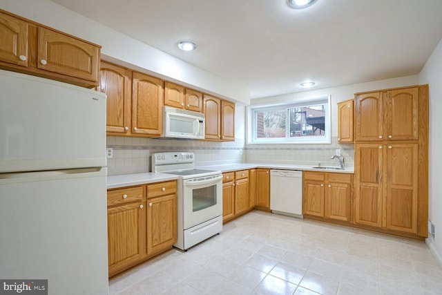 kitchen with tasteful backsplash, white appliances, and sink