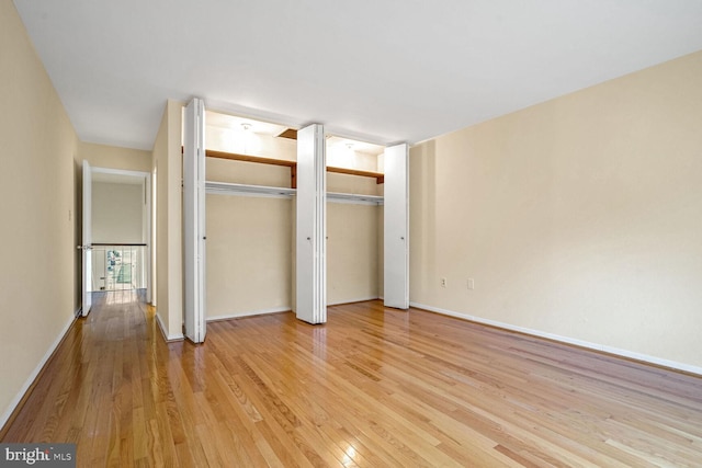 unfurnished bedroom featuring multiple closets and light hardwood / wood-style floors