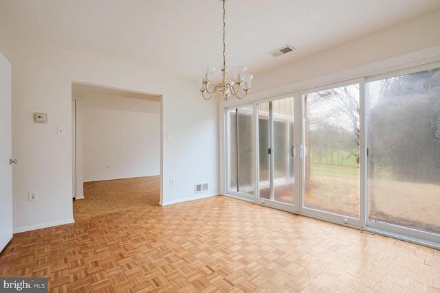 unfurnished dining area with an inviting chandelier and parquet floors