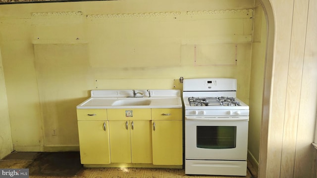 kitchen featuring white gas stove and sink