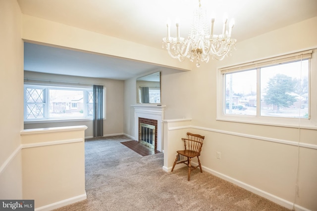 living room with a brick fireplace, a notable chandelier, and light colored carpet