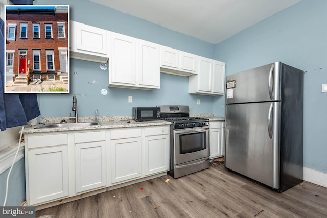 kitchen with white cabinetry, light hardwood / wood-style flooring, stainless steel appliances, and sink