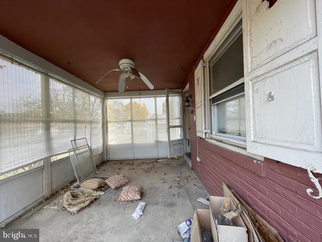 unfurnished sunroom featuring ceiling fan